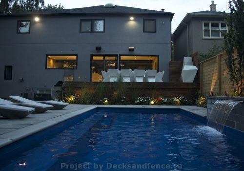 Complete landscaping project with deck outdoor kitchen and pool construction
